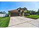 Well-maintained home featuring a two-car garage and manicured landscaping at 1704 Via Palermo St, Plant City, FL 33566