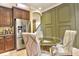 Cozy kitchen nook with stainless steel refrigerator and glass topped dining table at 1704 Via Palermo St, Plant City, FL 33566
