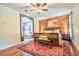 Spacious main bedroom with a wood accent wall, ceiling fan, and view to the luxury bathroom at 1704 Via Palermo St, Plant City, FL 33566