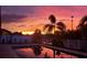 Backyard pool reflecting a stunning sunset, creating a picturesque and serene outdoor space at 1704 Via Palermo St, Plant City, FL 33566