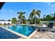 Backyard pool and lounge area surrounded by lush landscaping and a white fence at 1704 Via Palermo St, Plant City, FL 33566