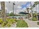 Beautiful community pool area featuring comfortable lounge chairs and shady awnings amidst lush landscaping at 1802 Bedford Ter # 187, Sun City Center, FL 33573