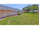 Exterior shot of the property featuring a large lawn and well-maintained landscaping at 1802 Bedford Ter # 187, Sun City Center, FL 33573