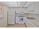 Cozy kitchen featuring white cabinetry, efficient appliances, and ample countertop space at 1802 Bedford Ter # 187, Sun City Center, FL 33573