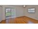 Bright living room with wood floors, fan, and sliding door access to the outdoors at 1802 Bedford Ter # 187, Sun City Center, FL 33573