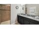 Bathroom featuring double sinks, granite countertops, and a tiled walk-in shower at 18796 Obregan Dr, Spring Hill, FL 34610