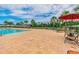 Community pool with an expansive lounge area, chairs, tables, and palm trees at 18796 Obregan Dr, Spring Hill, FL 34610