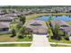 Beautiful home features a three-car garage, lush landscaping, and stunning backyard lake views at 18796 Obregan Dr, Spring Hill, FL 34610