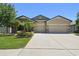 Beautiful single-story home with a well-maintained lawn, lush landscaping, and a two-car garage at 18796 Obregan Dr, Spring Hill, FL 34610