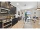 Modern kitchen with dark cabinetry, stainless steel appliances, and a view of the backyard and dining area at 18796 Obregan Dr, Spring Hill, FL 34610