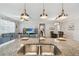 Bright kitchen with granite island, stainless sink, and view into the living area at 18796 Obregan Dr, Spring Hill, FL 34610