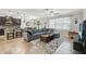 Open-concept living area with a gray sectional sofa, tile flooring, and seamless flow to the kitchen at 18796 Obregan Dr, Spring Hill, FL 34610