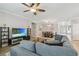 Spacious living room with a gray sectional sofa, TV, and view of the adjacent dining area at 18796 Obregan Dr, Spring Hill, FL 34610