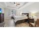 Bright main bedroom featuring a tray ceiling, ceiling fan, and large window at 18796 Obregan Dr, Spring Hill, FL 34610