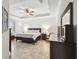 Spacious main bedroom featuring a tray ceiling, ceiling fan, and shiplap accent wall at 18796 Obregan Dr, Spring Hill, FL 34610