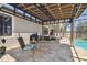 Outdoor patio featuring a grill and comfortable seating under a covered area, next to the pool at 18796 Obregan Dr, Spring Hill, FL 34610