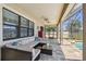 Covered patio with comfortable sectional seating, ceiling fans, and access to the screened-in pool area at 18796 Obregan Dr, Spring Hill, FL 34610