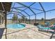 Screened-in pool with lounge chairs and patio furniture overlooking the serene pond in the backyard at 18796 Obregan Dr, Spring Hill, FL 34610
