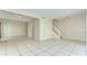 Open-concept living room with tile flooring, a staircase, and ample natural light at 1881 N Hercules Ave # 1303, Clearwater, FL 33765
