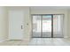 An airy living room with vertical blinds, tile floors, and a sliding door to the outside at 1881 N Hercules Ave # 1303, Clearwater, FL 33765