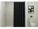 Bright bathroom featuring a shower with tile surround and black shower curtain at 2292 Blue Grosbeak Pl, Wimauma, FL 33598
