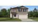 Two-story home with a two-car garage, neutral siding, and well-maintained landscaping at 2292 Blue Grosbeak Pl, Wimauma, FL 33598