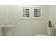 Stylish powder room featuring a pedestal sink, toilet, and decorative wall art at 2292 Blue Grosbeak Pl, Wimauma, FL 33598