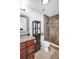 Neutral bathroom featuring granite counters, a tiled shower, a dark wood cabinet, and decorative tile detail at 2366 Covington Dr, Clearwater, FL 33763