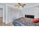 Bedroom features a ceiling fan, dark wood dresser and ample closet space behind sheer curtains at 2366 Covington Dr, Clearwater, FL 33763