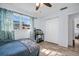 A bedroom with light blue walls has plank flooring, a ceiling fan, and a large window with patterned curtains at 2366 Covington Dr, Clearwater, FL 33763