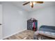 Bedroom featuring wood floors, a ceiling fan, and a patterned dresser with clothes hanging on the side at 2366 Covington Dr, Clearwater, FL 33763