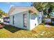 Exterior corner view of the home featuring a fenced backyard, light blue paint, and green grass at 2366 Covington Dr, Clearwater, FL 33763
