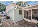 Exterior view of the home, showing the screened-in lanai, a small window, and the back patio at 2366 Covington Dr, Clearwater, FL 33763