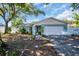 Charming single-story home featuring a manicured lawn, mature tree, and a two-car garage at 2366 Covington Dr, Clearwater, FL 33763