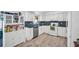 Efficient kitchen with white cabinets, tile backsplash and stainless steel appliances at 2366 Covington Dr, Clearwater, FL 33763