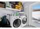 Bright laundry area featuring a front-load washer and dryer with white shelving at 2366 Covington Dr, Clearwater, FL 33763