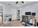 Office with a ceiling fan, wood floors, two bookshelves, a black chair, a white closet and a stand-up desk setup at 2366 Covington Dr, Clearwater, FL 33763