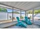Relaxing screened-in patio with turquoise Adirondack chairs, a grill, and a view of the fenced-in yard at 2366 Covington Dr, Clearwater, FL 33763