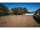 A large backyard with mature trees and a privacy fence creates a secluded outdoor space at 2700 Westchester N Dr, Clearwater, FL 33761