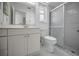 Bathroom showcasing white vanity with sink, toilet, and a glass-enclosed shower at 2700 Westchester N Dr, Clearwater, FL 33761
