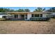 A view of the back of the house with a screened porch and windows overlooking the spacious backyard at 2700 Westchester N Dr, Clearwater, FL 33761