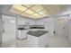 Bright kitchen featuring white cabinets, an island, and unique tiled ceiling at 2700 Westchester N Dr, Clearwater, FL 33761