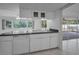White kitchen featuring stone countertops, undermount sink and lots of natural light at 2700 Westchester N Dr, Clearwater, FL 33761