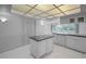 Kitchen with white cabinets, a kitchen island, and a unique tiled ceiling at 2700 Westchester N Dr, Clearwater, FL 33761