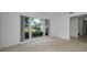 Bright, carpeted living room with a large window overlooking the front yard, showcasing the home's natural light at 2700 Westchester N Dr, Clearwater, FL 33761