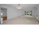 Spacious living area with large window, neutral tile flooring, and access to an adjacent room at 2700 Westchester N Dr, Clearwater, FL 33761