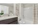 Clean bathroom with a shower-tub combo, vanity with granite countertop, and elegant botanical wall decor at 3332 Ivy Hollow Dr, Plant City, FL 33565