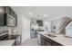 Open-concept kitchen boasts stainless steel appliances, dark cabinetry, island, and staircase access at 3332 Ivy Hollow Dr, Plant City, FL 33565