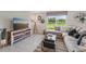 Cozy living room features a comfortable sectional sofa, stylish decor, and a large window overlooking the lawn at 3332 Ivy Hollow Dr, Plant City, FL 33565