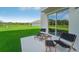Relaxing outdoor patio with modern furniture, overlooking a spacious, green lawn and natural scenery at 3338 Ivy Hollow Dr, Plant City, FL 33565